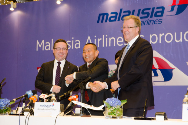 Alan Joyce, Ahmad Jauhari Yahya, and Bruce Ashby, celebrate after signing the contract