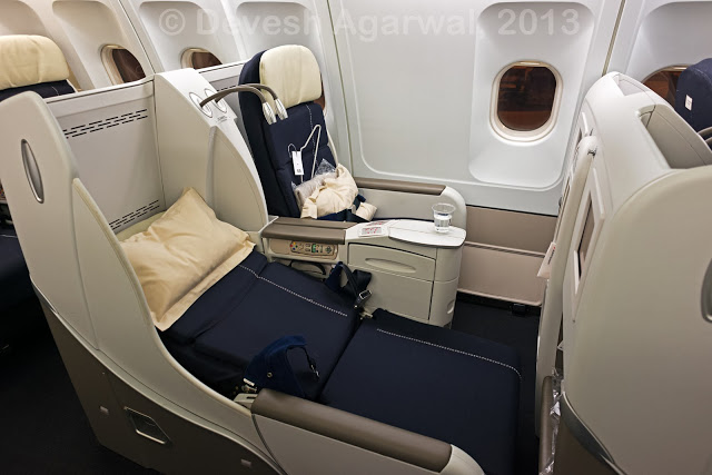 Business class seats in the upright and fully reclined position.
