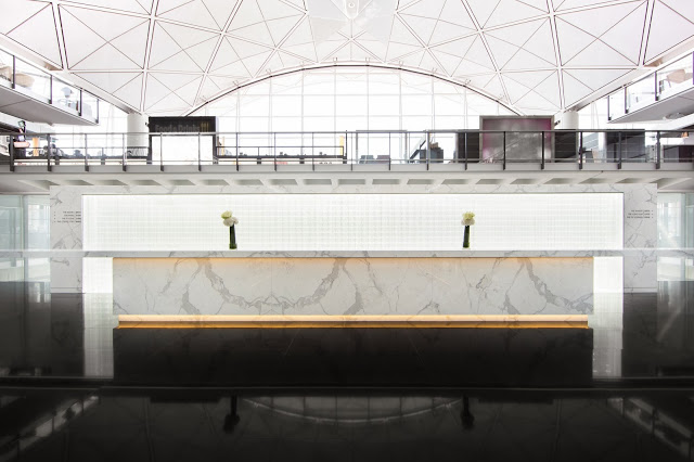 The luminous reception wall, made of Venetian glass tiles by Fabbian of Italy.