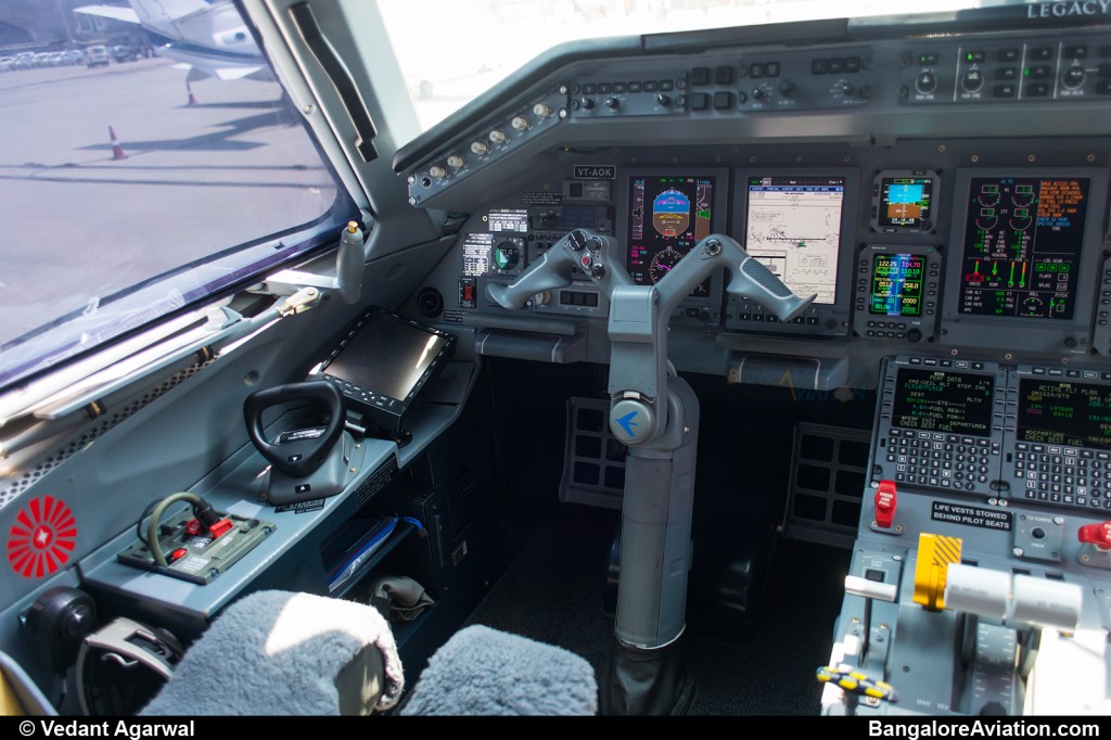 Close up of the captain's seat on the Legacy 600. Behind the yoke, the airport information chart is displayed.