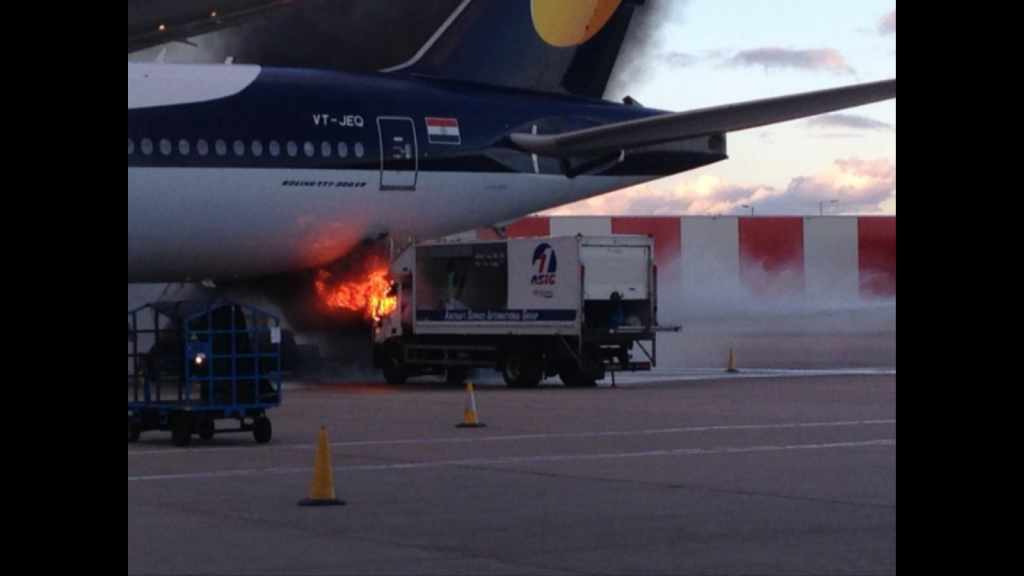 A cleaning truck on fire just below Jet Airways Boeing 777-300ER VT-JEQ at London Heathrow airport