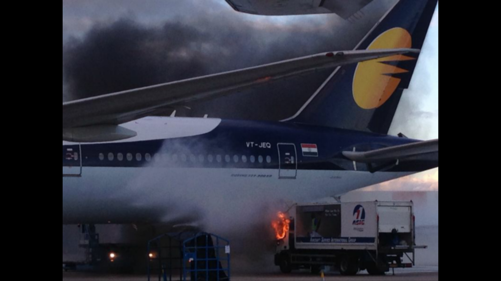 Fire-fighting a cleaning truck fire just below Jet Airways Boeing 777-300ER VT-JEQ at London Heathrow airport