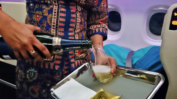 Singapore Airlines stewardess serving Taittinger Prelude Champagne.