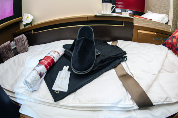 Etihad Boeing 787-9 first class turn-down service, amenity kit (top-left), pyjamas, and herbal tea infusion.