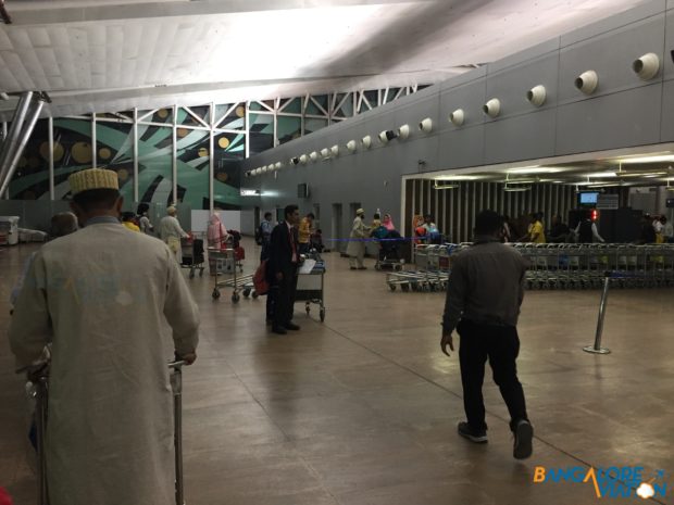 The long x-ray line at Ahmedabad airport with a Kuwait air sign on it.